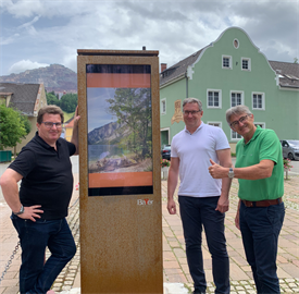 3 Männer stehen neben der neuen digitalen Amtstafel in Eisenerz
